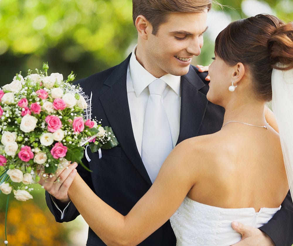 Mariés partageant une danse avec un bouquet dans la main de la femme
