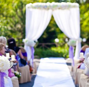 Autel de mariage avec chemin de tapis blanc et entouré de convives