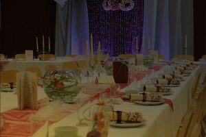 Tables de repas de mariage dressées avec chandelier et autel en fond